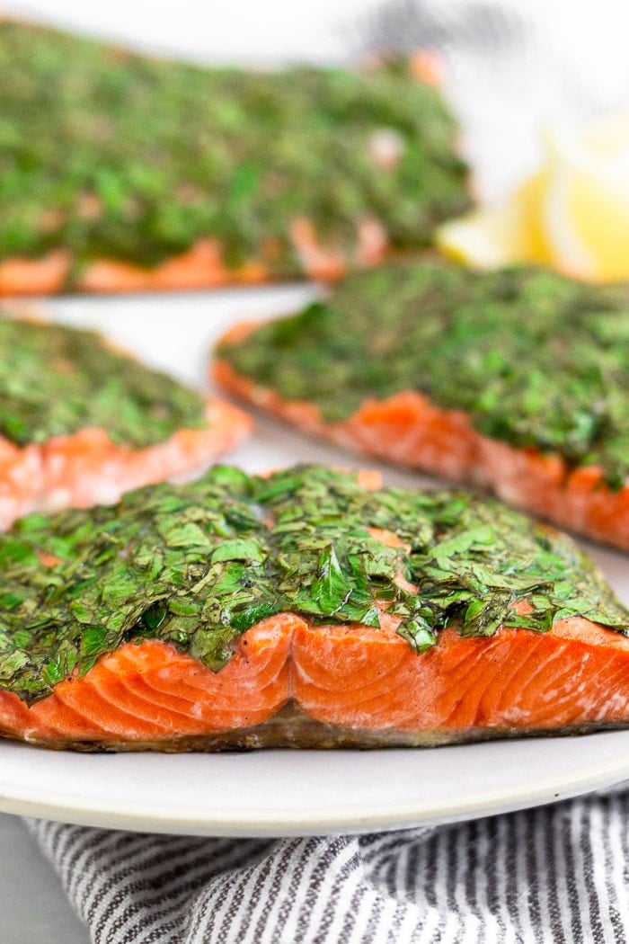Plate filled with filets of herb grilled salmon and lemon wedges.