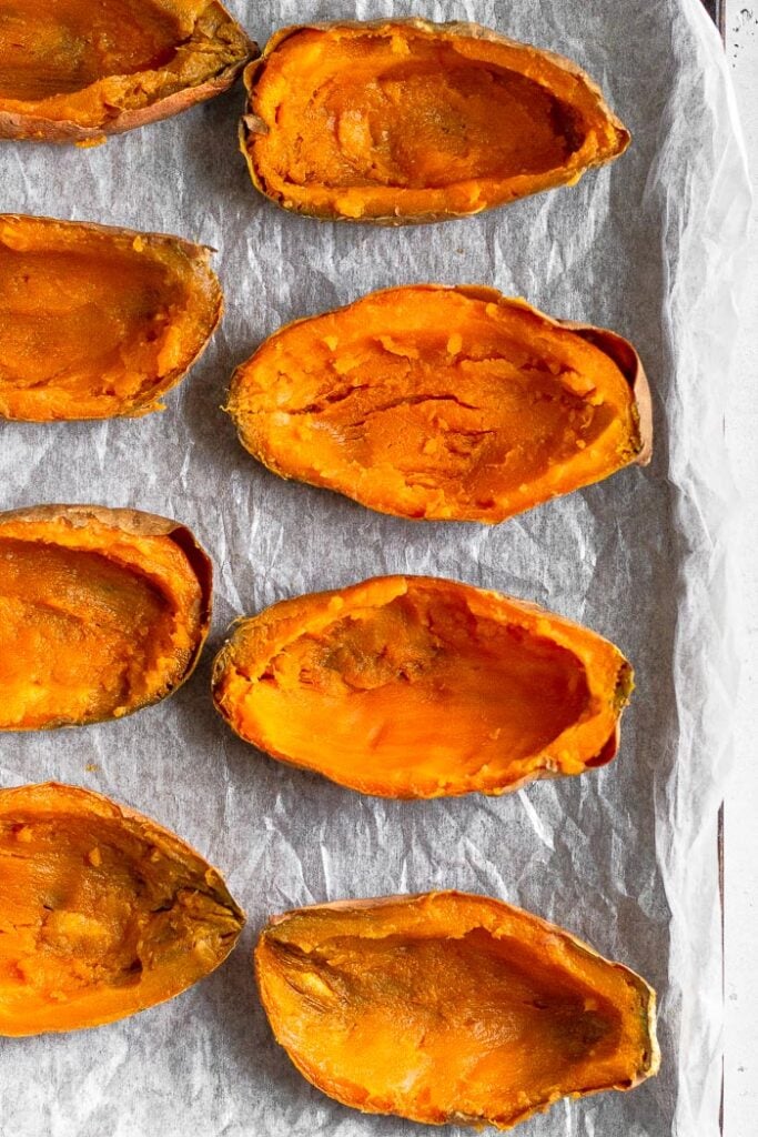 Sweet potatoes cut in half lengthwise with the inside flesh scooped out.