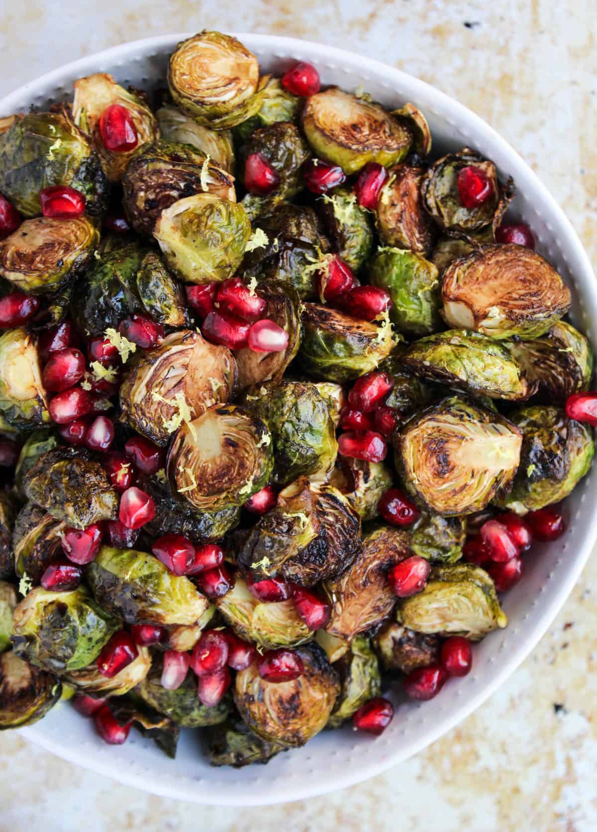 These Ginger & Balsamic Roasted Brussels Sprouts with Pomegranates are an easy & healthy side dish that are just as festive as the holiday season - Eat the Gains