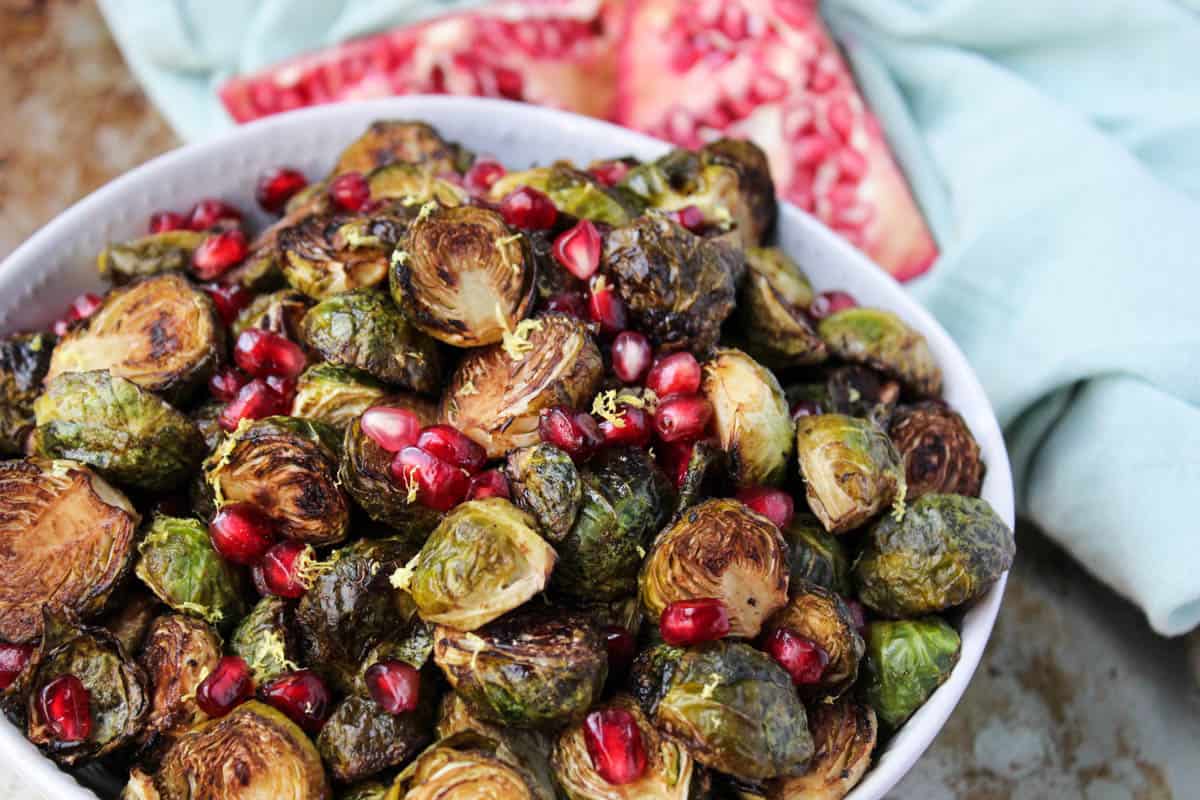 These Ginger & Balsamic Roasted Brussels Sprouts with Pomegranates are an easy & healthy side dish that are just as festive as the holiday season - Eat the Gains