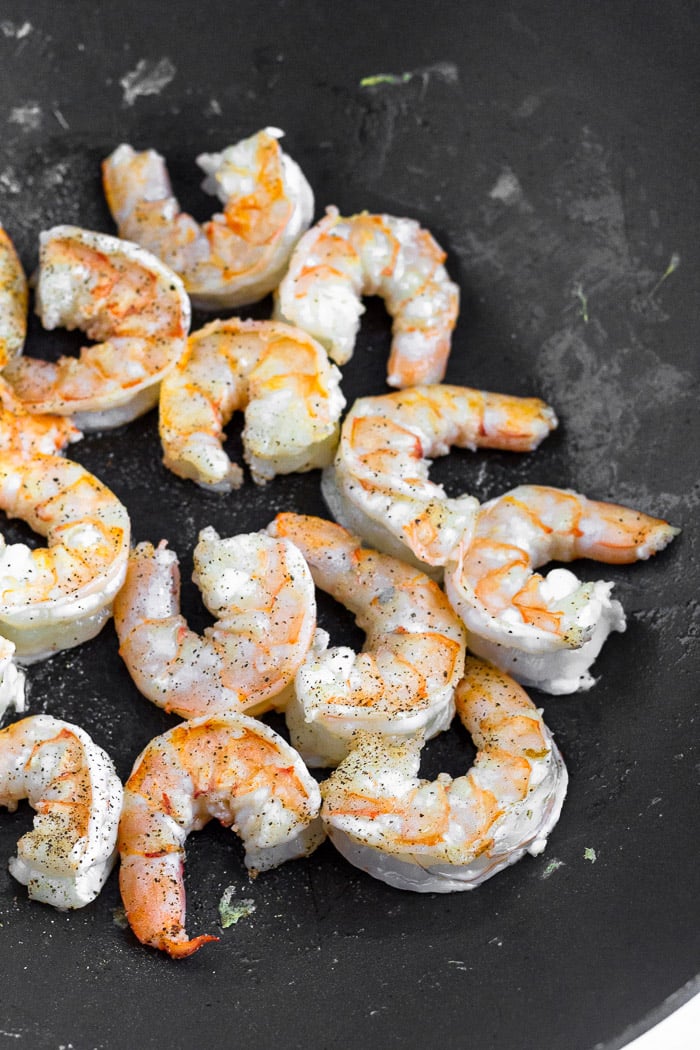 Wok with cooked shrimp in it.