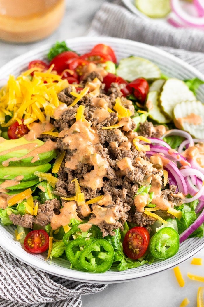 Cheeseburger salad with lettuce, ground beef, tomato, cheese, avocado, special sauce, pickles, jalapeños, onions, and special sauce dressing.