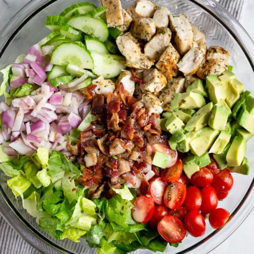 Large glass bowl filled with chopped chicken bacon ranch ranch salad.