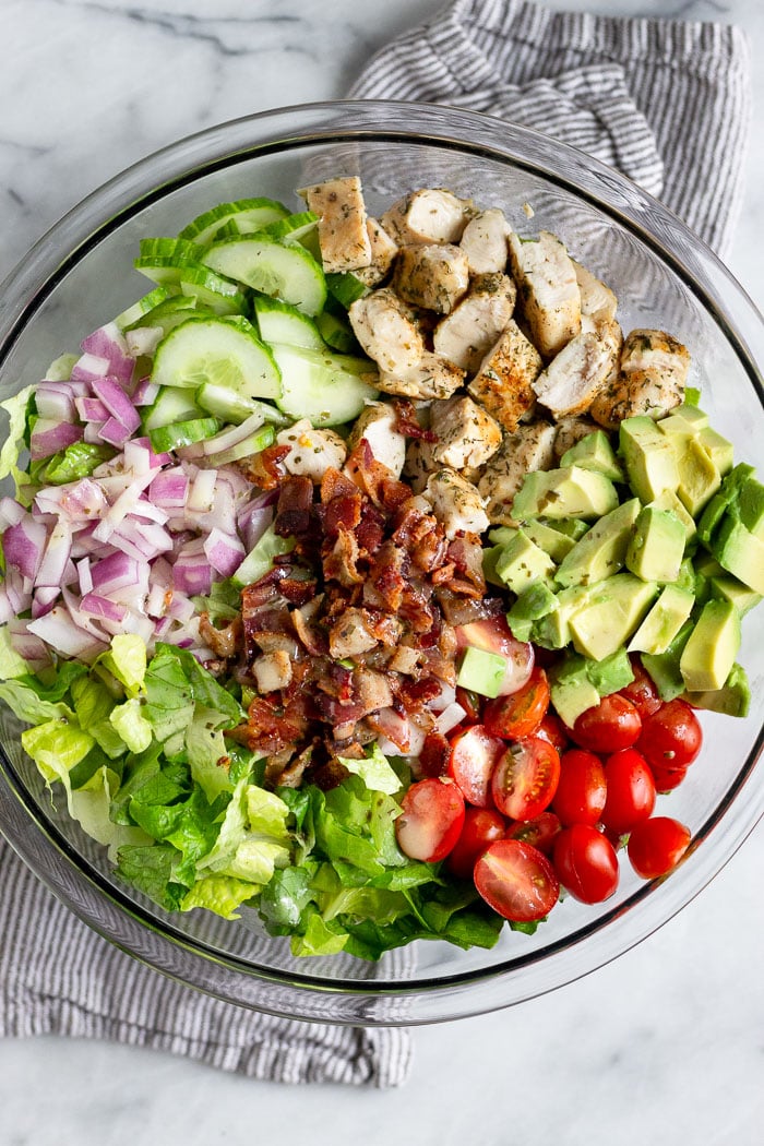 Large glass bowl filled with chopped chicken bacon ranch ranch salad.