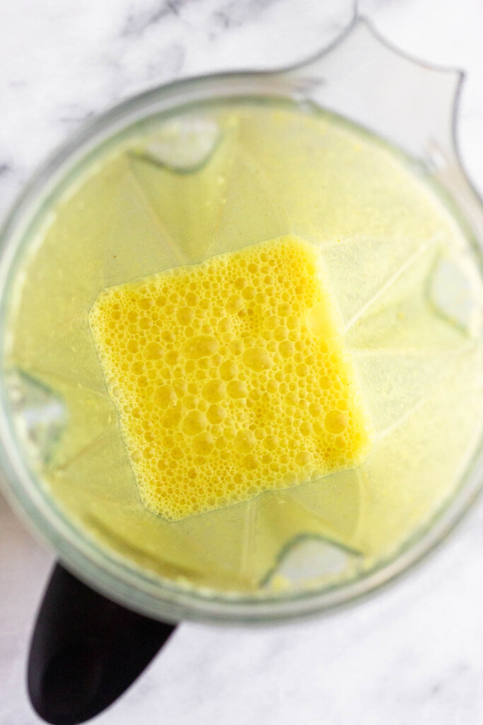Overhead shot of turmeric golden milk in a blender.
