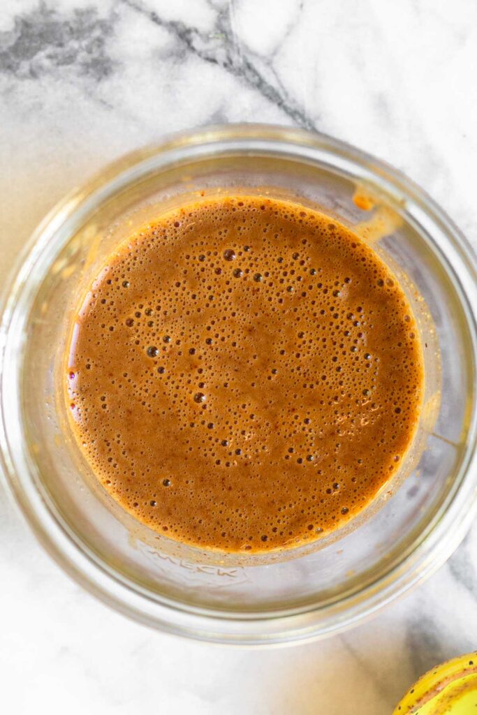 Small jar with creamy balsamic dressing in it.