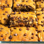 A pan of banana bread bars with one of the bars higher than the others so you can see the inside of it.