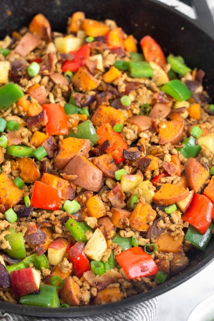 Chicken sweet potato hash in a large cast iron skillet.
