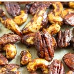 Close up of candied nuts on a large baking sheet.