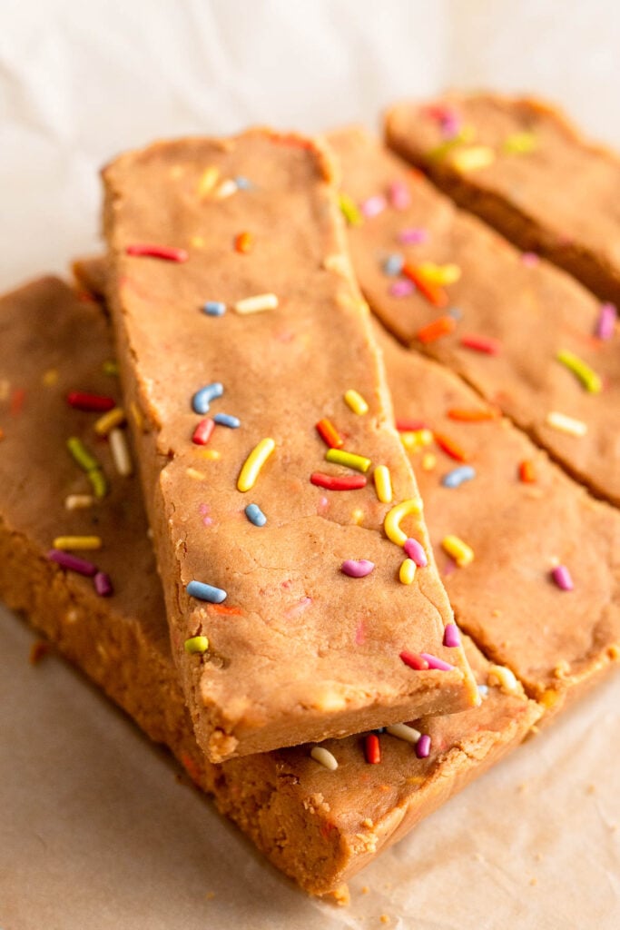 Four birthday cake protein bars lined up next to each other with one top top of them all.