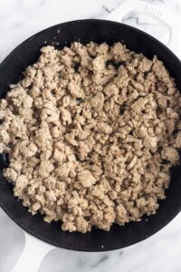 Cast iron skillet filled with sautéed ground turkey.
