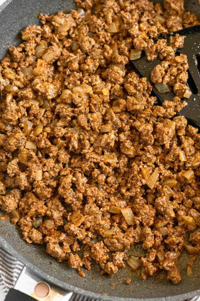 A close up of beef taco meat in a large skillet.