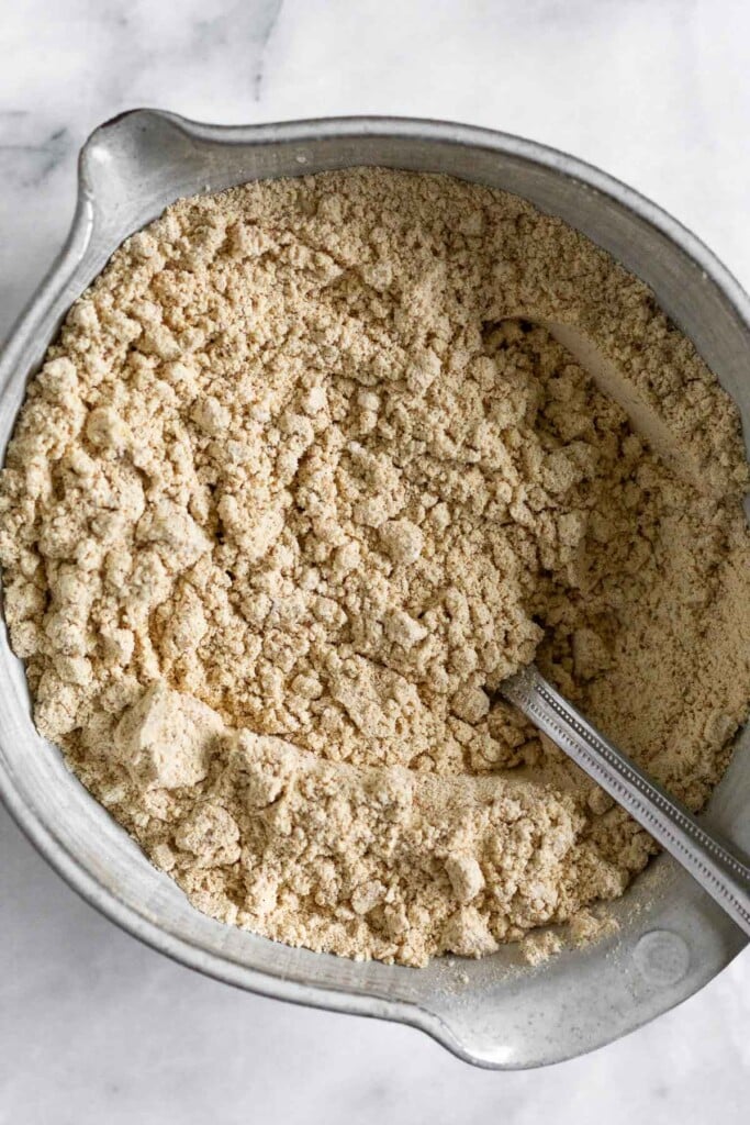 An overhead shot of a bowl with flour and spices mixed together. A fork is also in it.