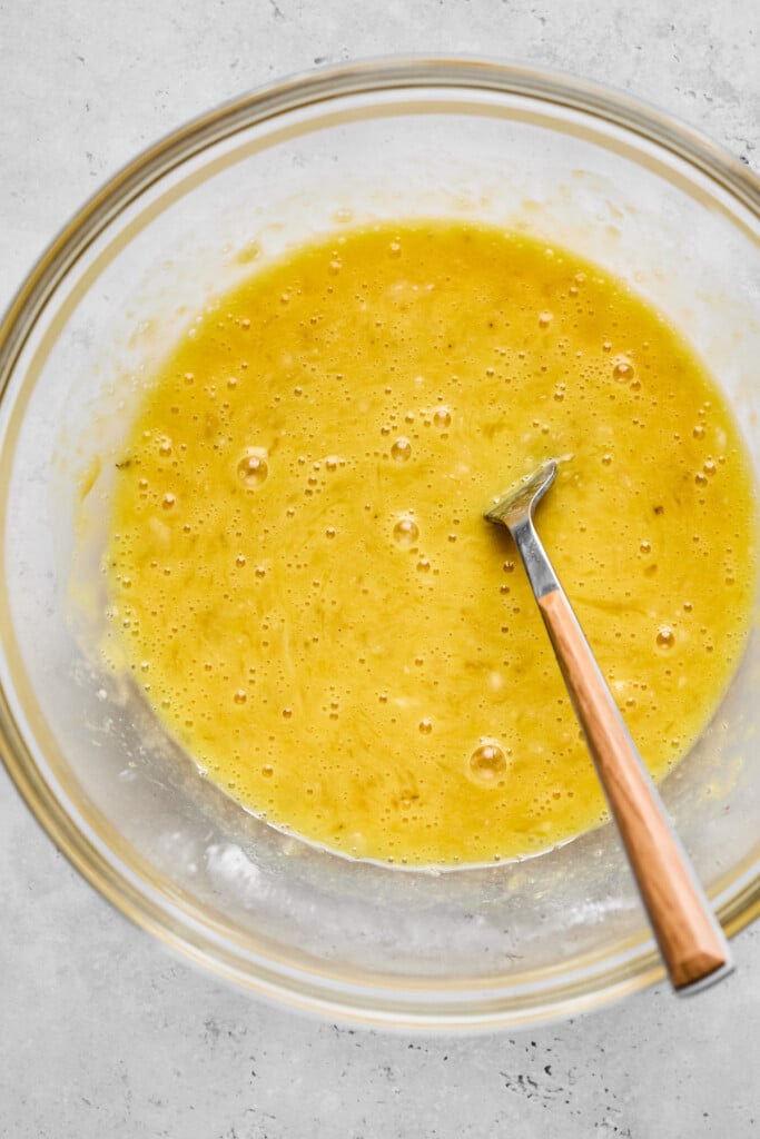 A glass bowl with a wet batter with a fork in it.
