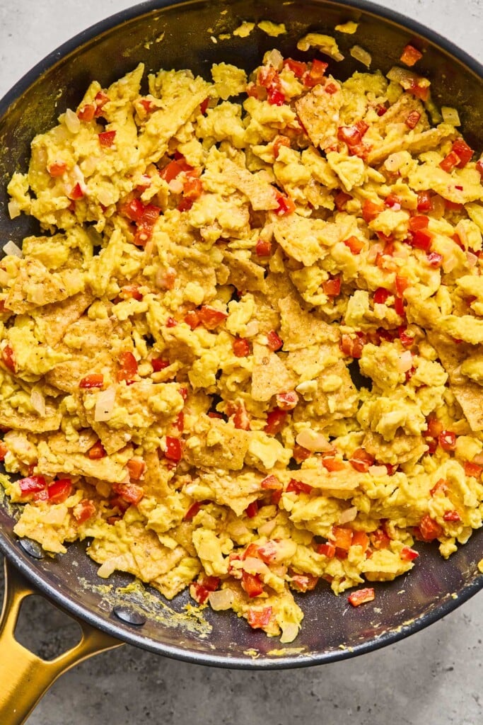 Breakfast migas with onions and peppers in a large skillet.