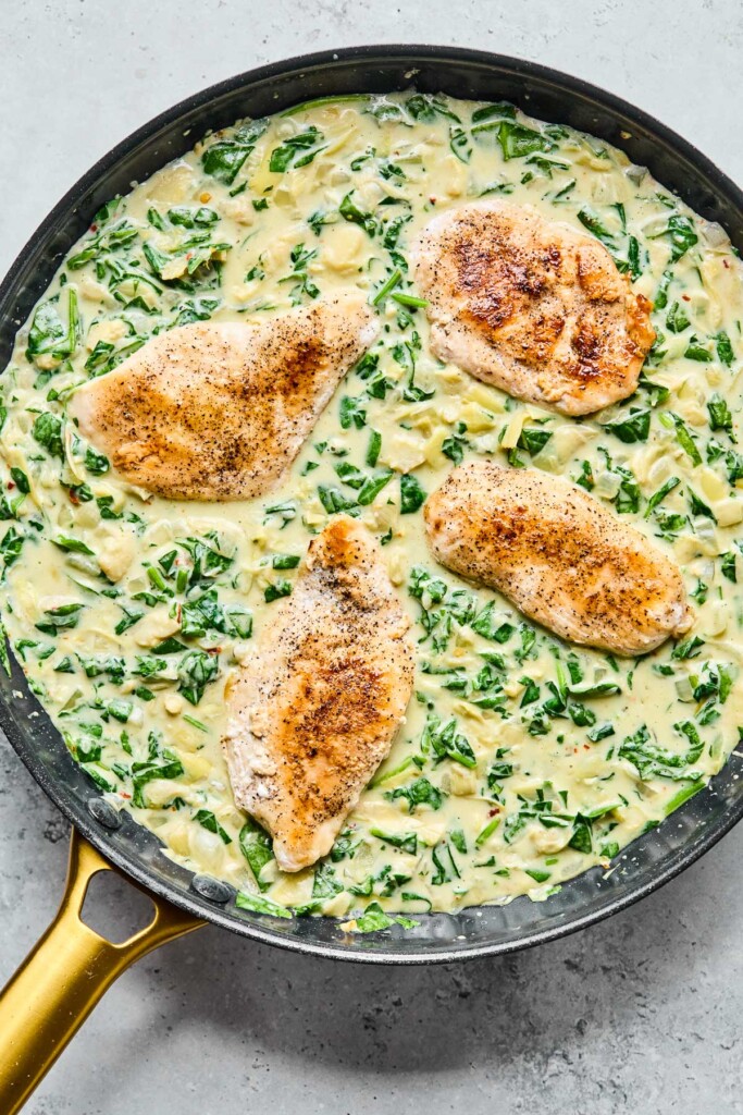 Spinach artichoke chicken in a large skillet.