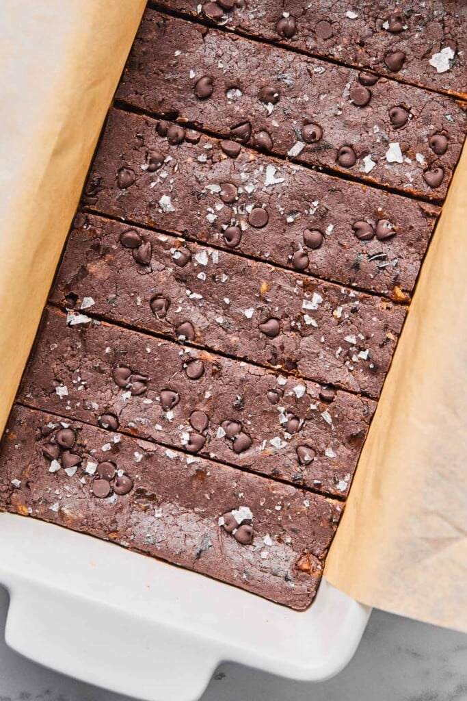 A bread pan filled with six chocolate protein bars sprinkled with flaky sea salt.