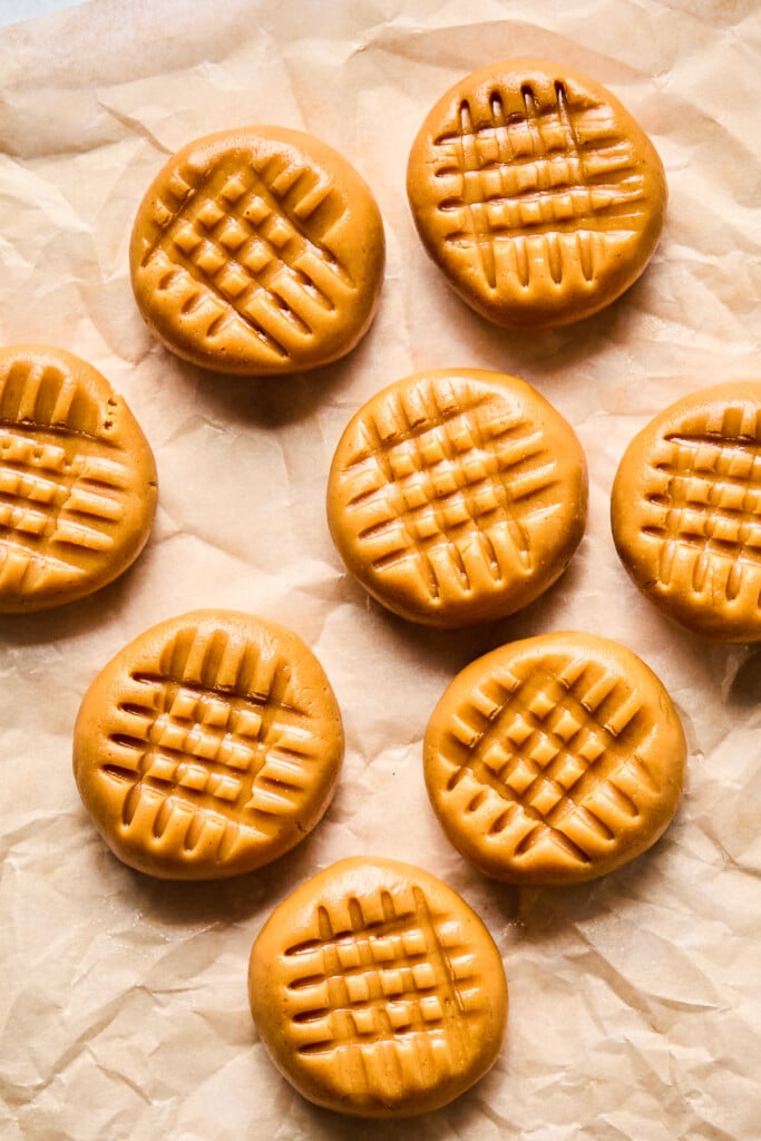 Overhead shot of no bake peanut butter cookies spread out on a piece of parchment paper.